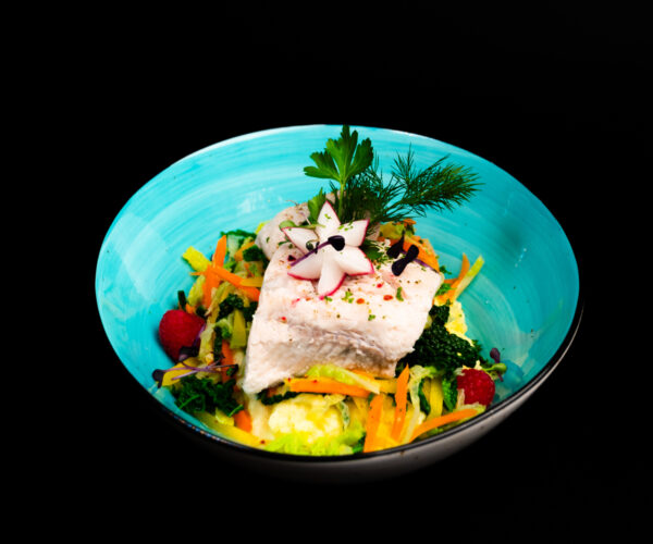 Gedünstetes Welsfilet, auf Kartoffelpüree mit Kirsch-tomaten-Knoblauch-Gemüse und Petersilien-Mango-Salsa